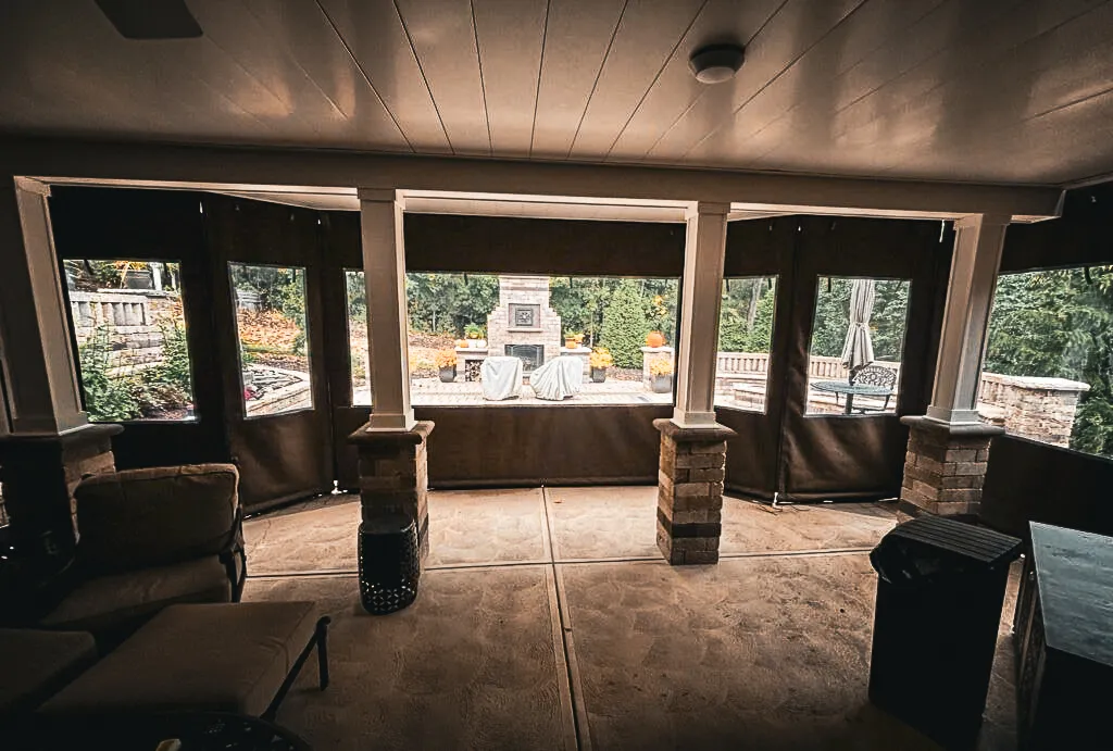 Commercial exterior patio with interior shades, signs, and awnings overlooking garden