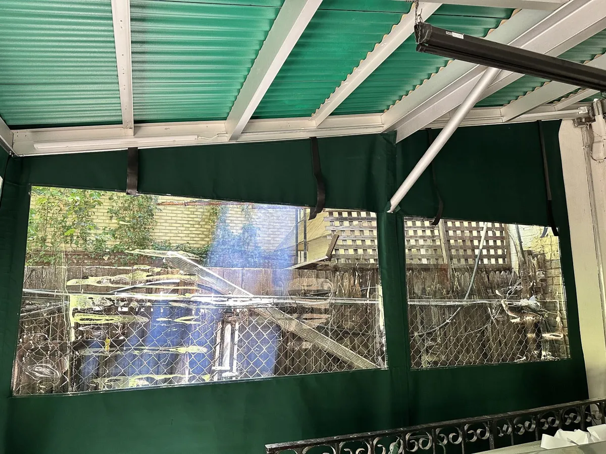 Commercial exterior with green shades, awnings, and transparent signs