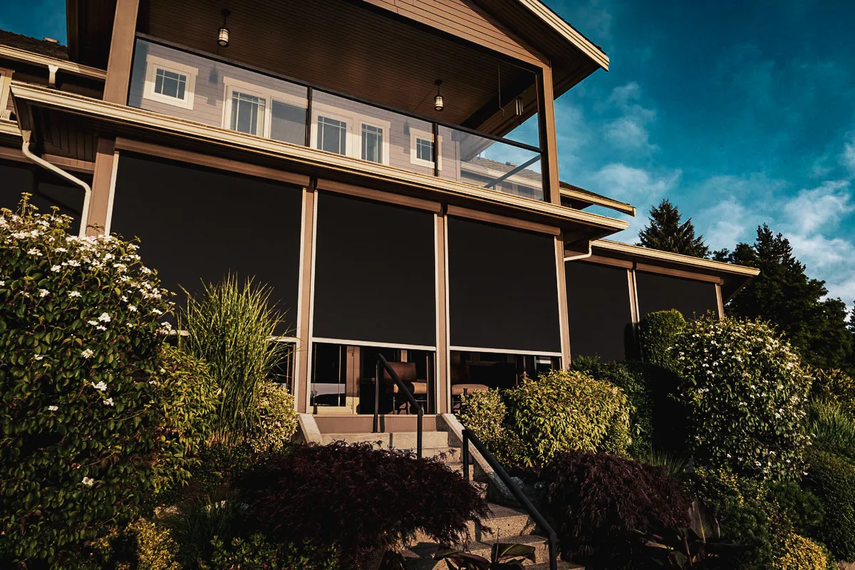 Commercial exterior with glass windows, shades, and landscaped entrance