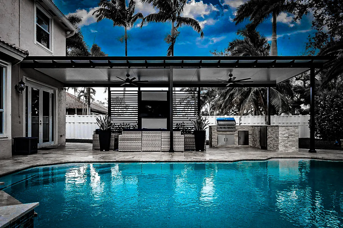 Commercial exterior with pool, shades, awnings, and outdoor kitchen under palm trees