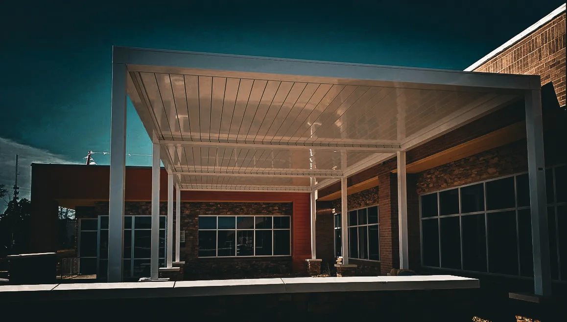 Commercial building exterior with stone walls, large windows, and metal awning shades