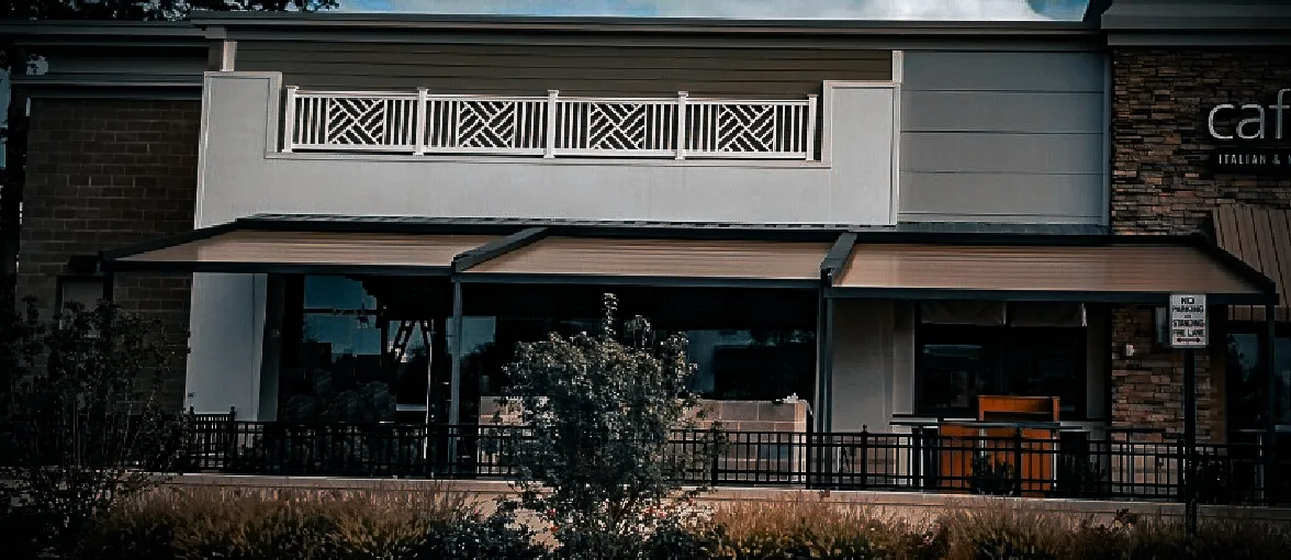 Commercial exterior with decorative signs, awnings, shades, and stone facade