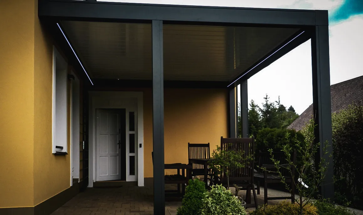 Commercial exterior with white door, shades, awnings, and modern seating area