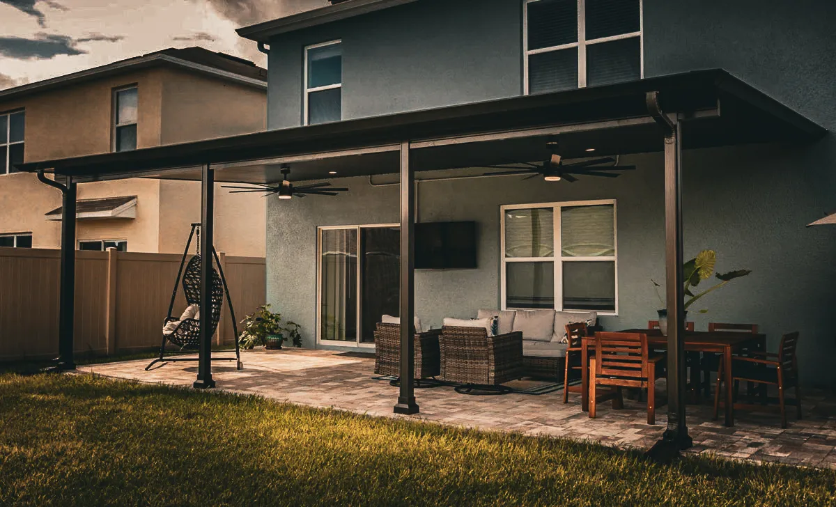 Commercial exterior with shaded patio, signs, awnings, and outdoor furniture