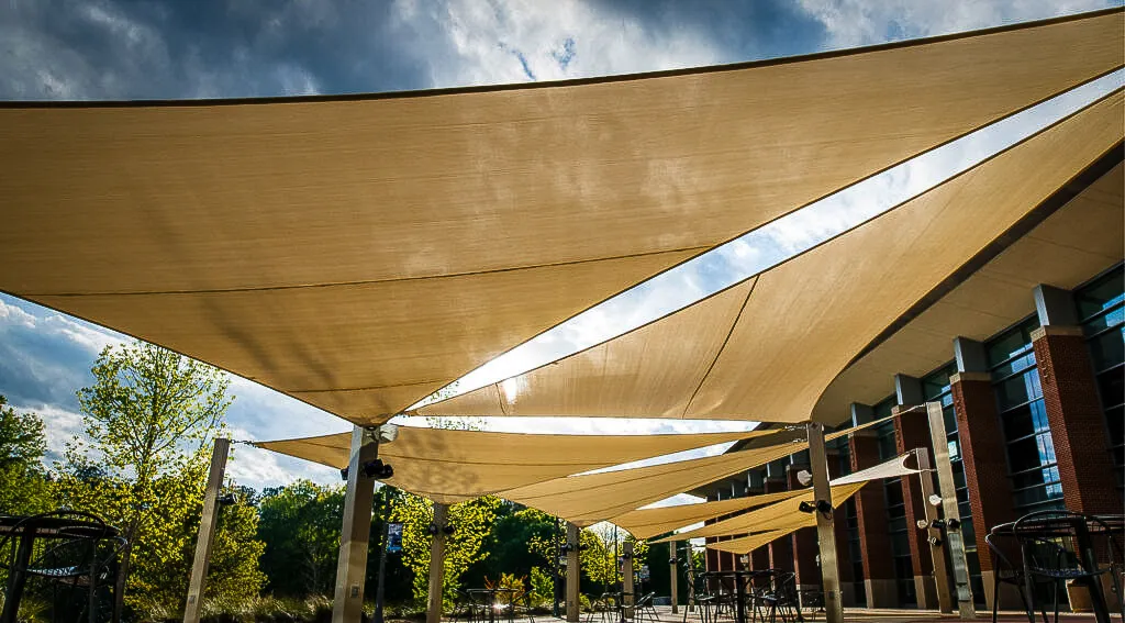Commercial exterior with triangular shade sails and awnings over outdoor seating