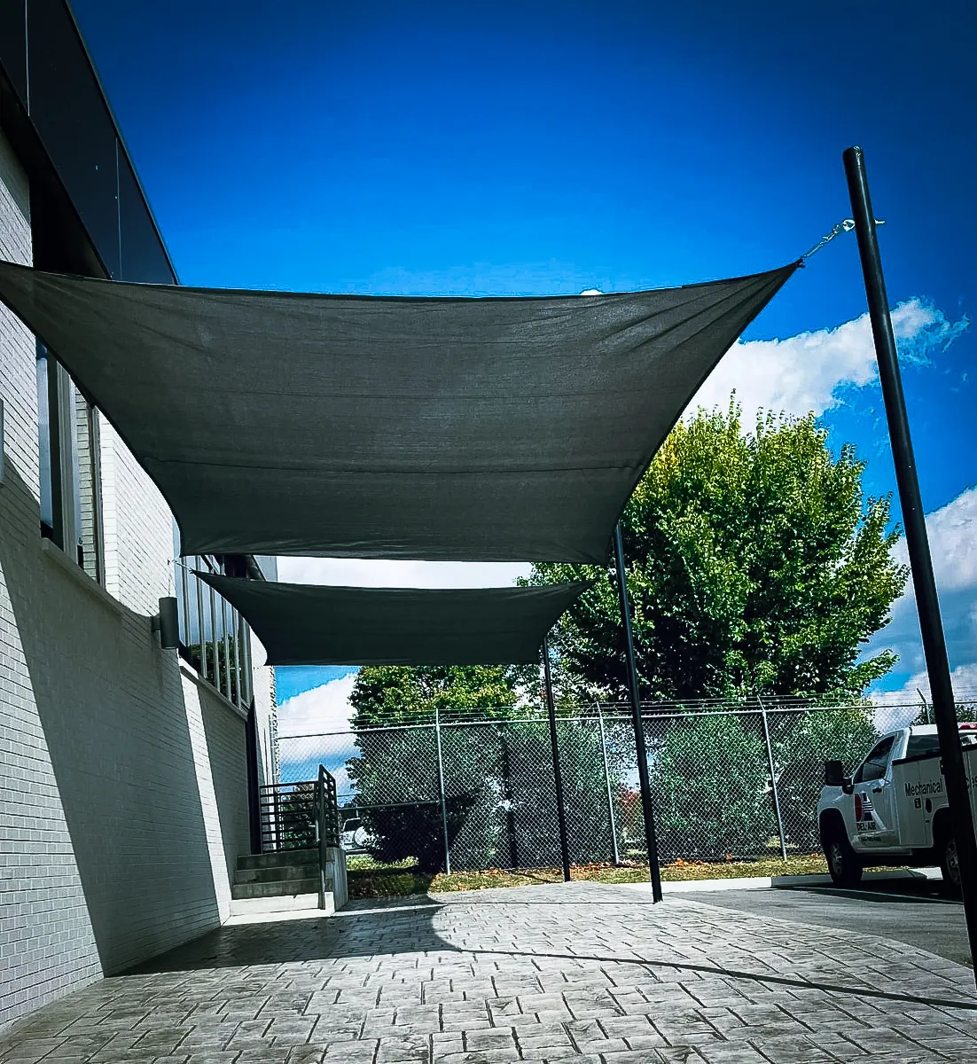 Commercial exterior with shade sails, awnings, and architectural signs