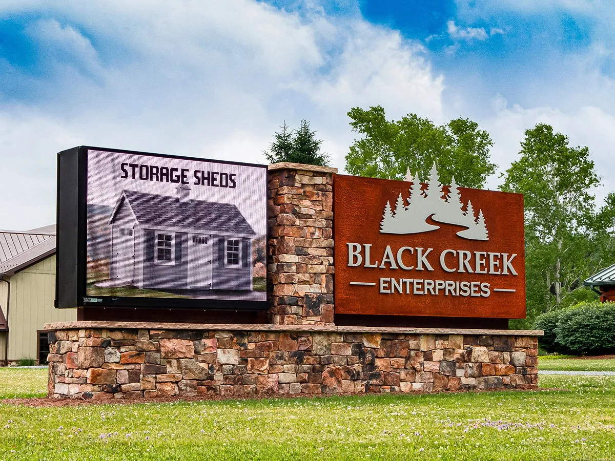 Commercial exterior sign for Black Creek Enterprises with storage sheds display