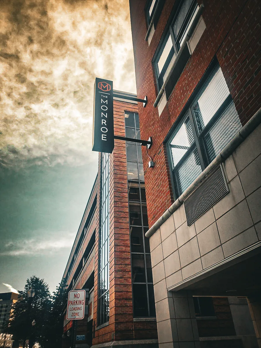 The Monroe commercial building with exterior signs, awnings, and urban shades
