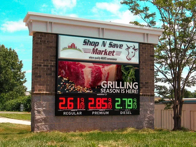 Commercial exterior sign with fuel prices and grilling season advertisement