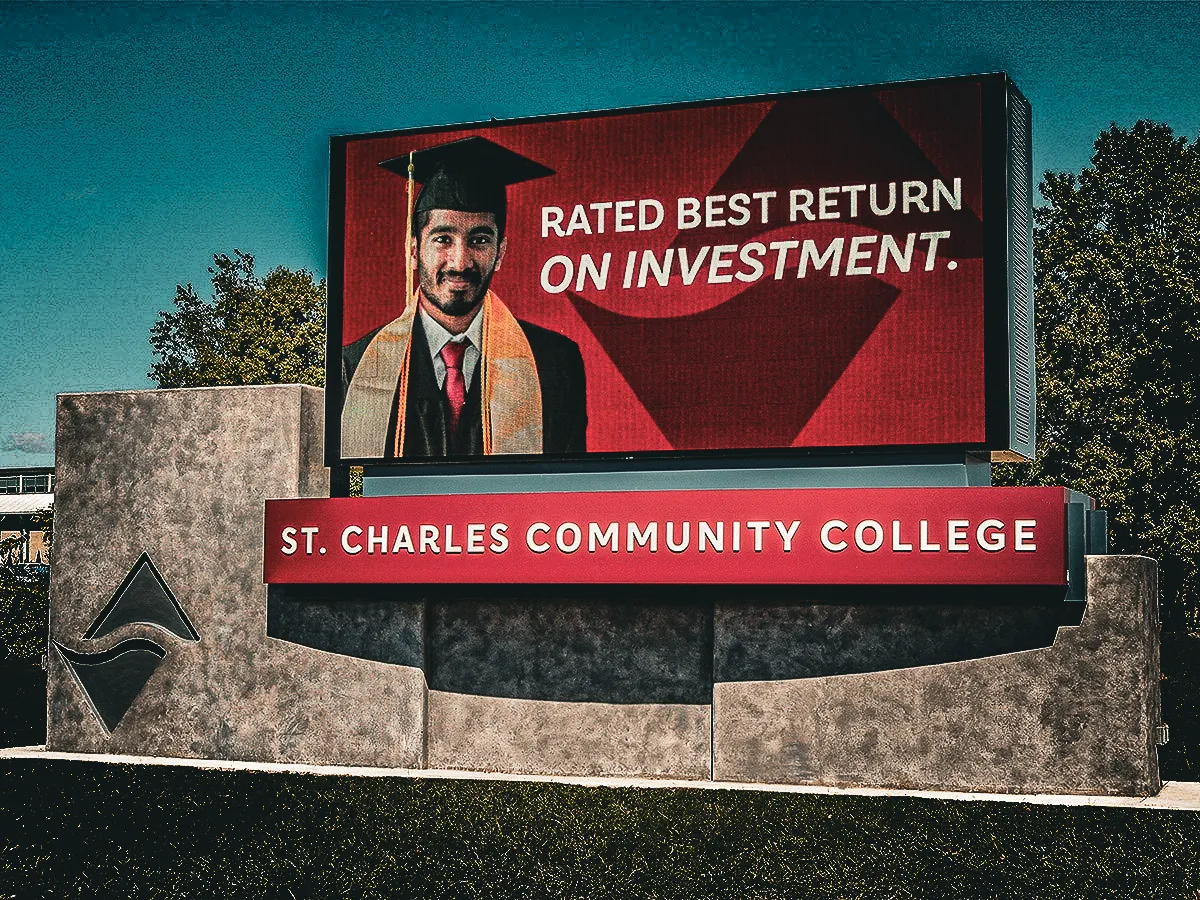 Commercial exterior sign for St. Charles Community College with graduation-themed awnings