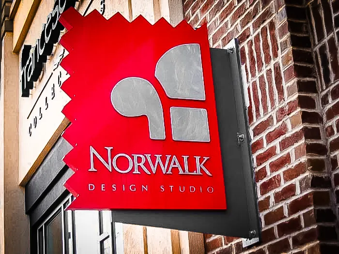 Commercial exterior sign for Norwalk Design Studio with red awning