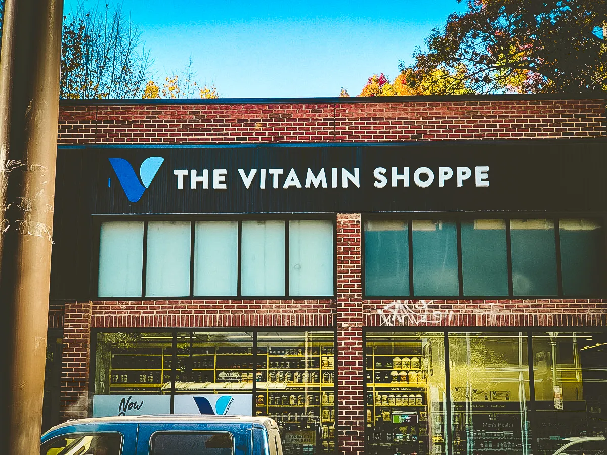 Commercial exterior of The Vitamin Shoppe with storefront signs and awnings