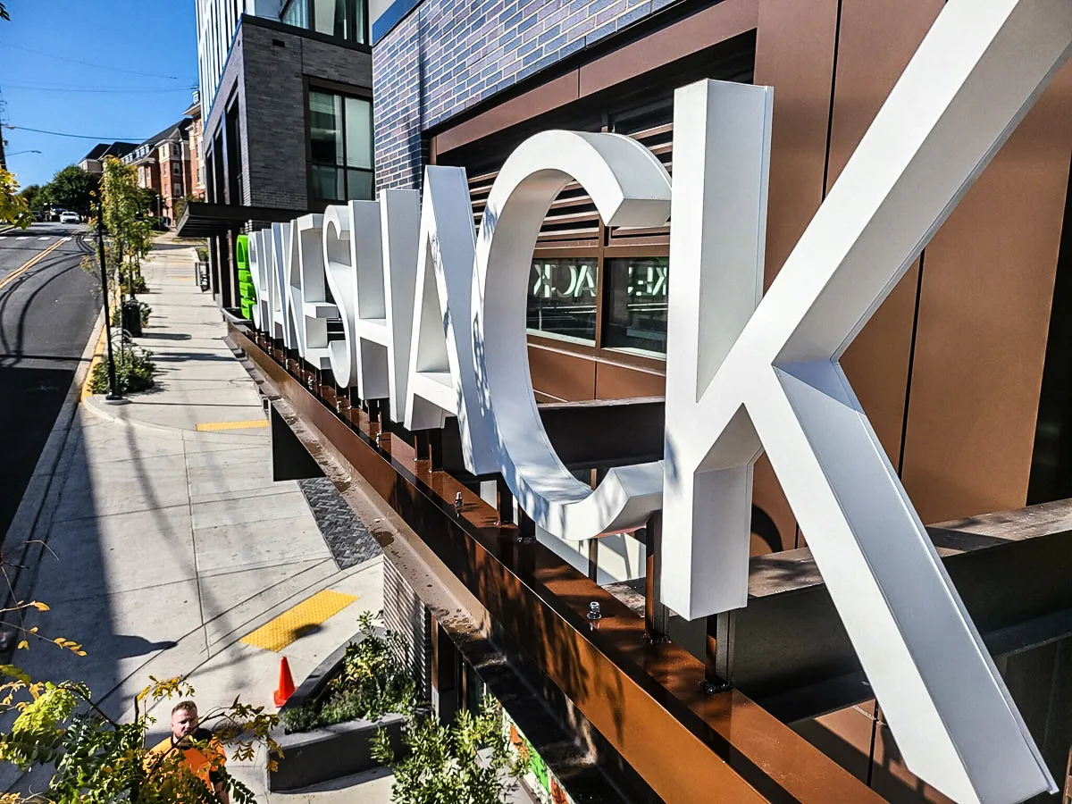 Commercial exterior with large 3D signs and awnings on modern building facade