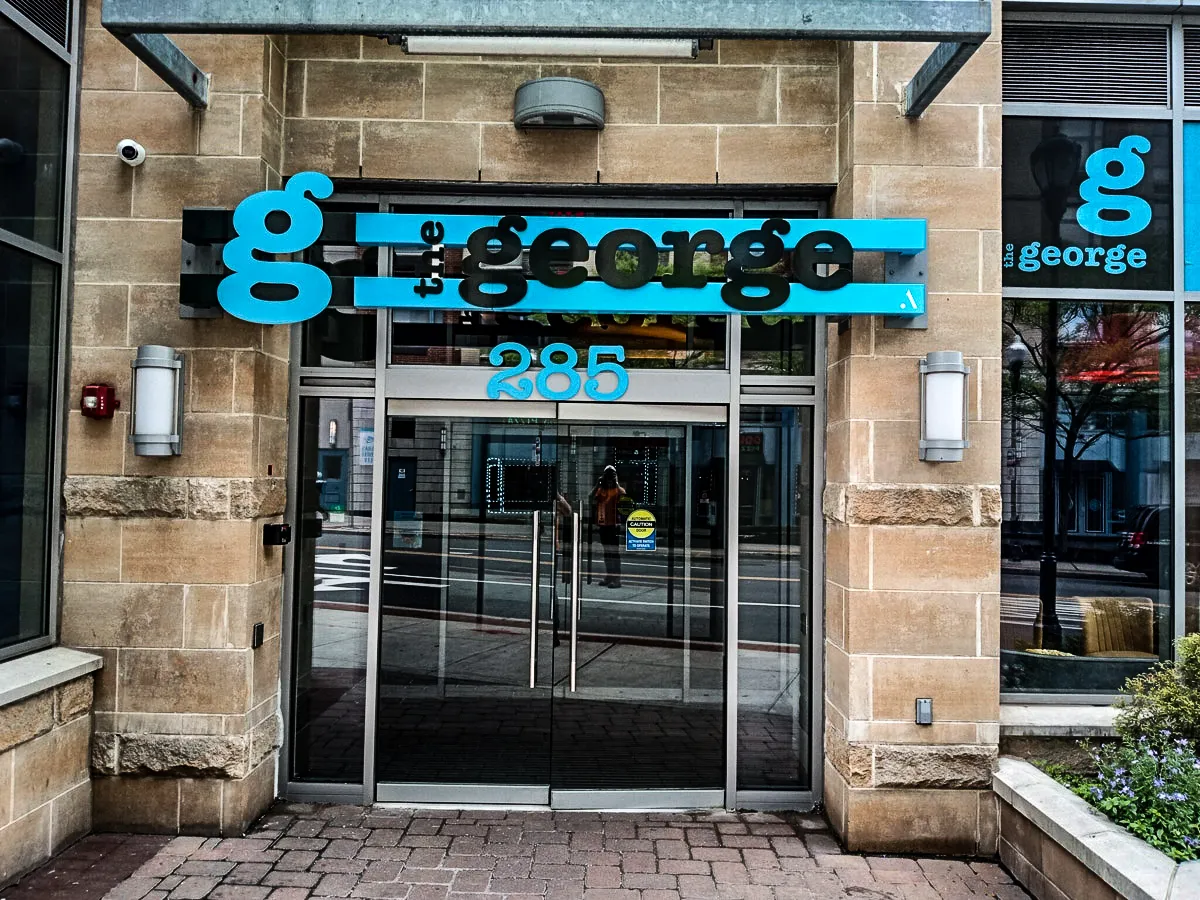 Commercial exterior with blue 'George' signs, awnings, and glass entrance