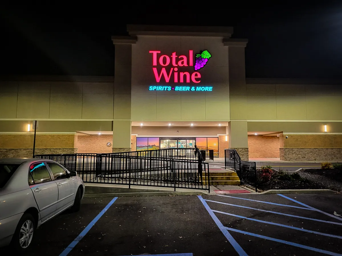 Commercial exterior of Total Wine with illuminated signs, awnings, and accessible entrance