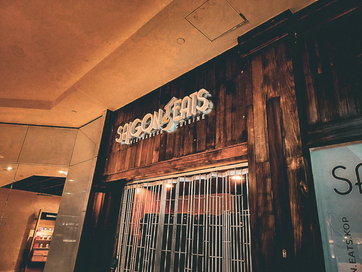 Commercial interior and exterior of Saigon Eats with rustic signs and shades