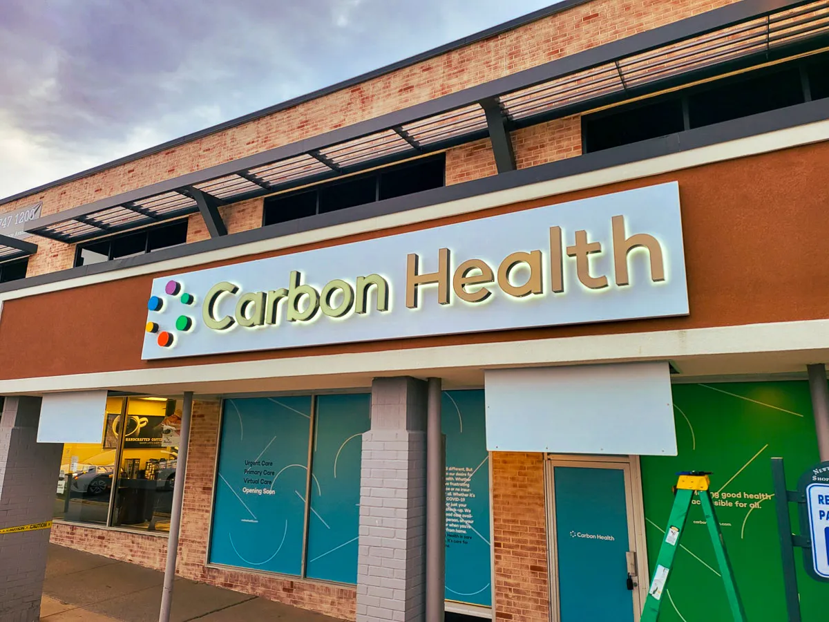 Commercial exterior with Carbon Health signs, awnings, and shades
