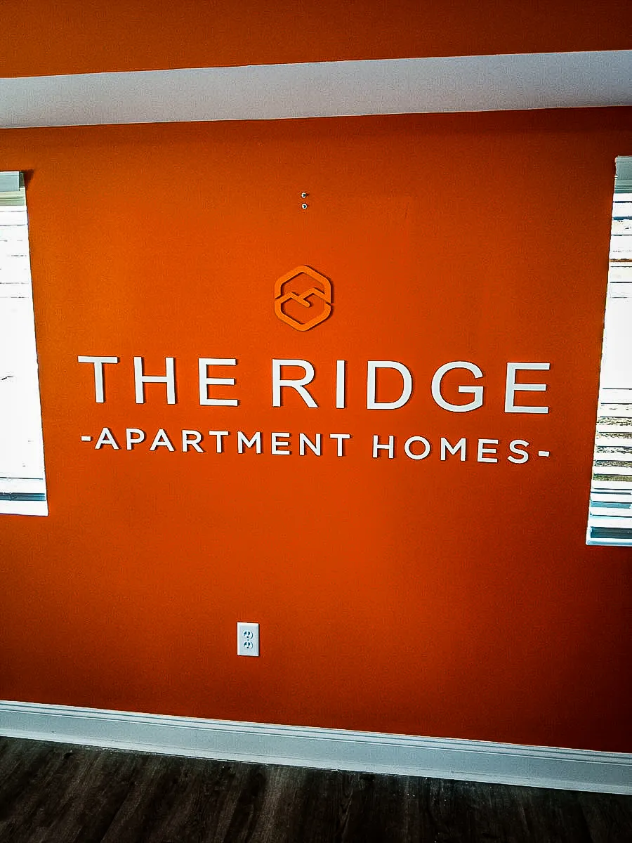 Commercial interior sign for The Ridge Apartment Homes with exterior branding