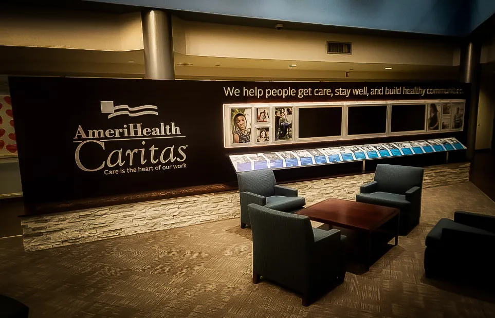 Commercial interior with AmeriHealth Caritas signs, shades, and lobby seating