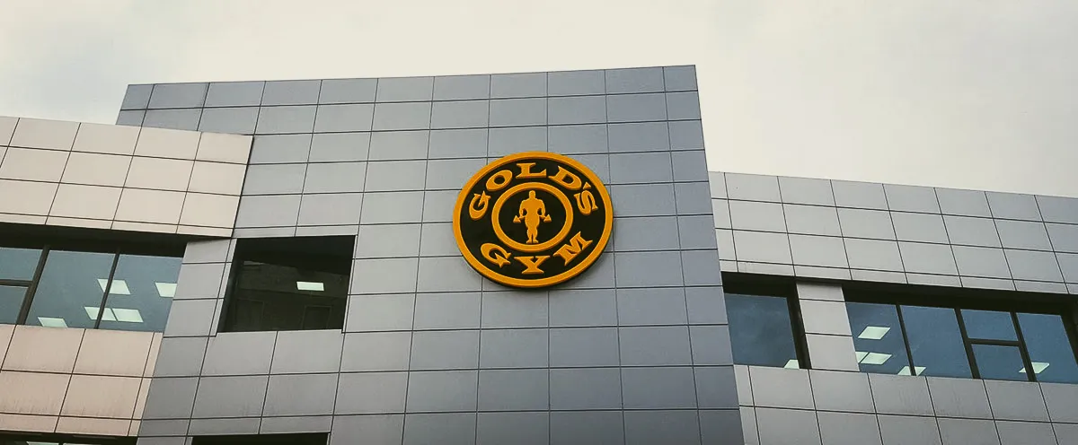 Commercial exterior with Gold's Gym sign on modern building with shades