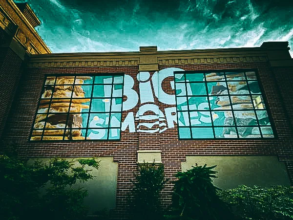 Commercial exterior with Big Melt signs, awnings, and shades on brick building