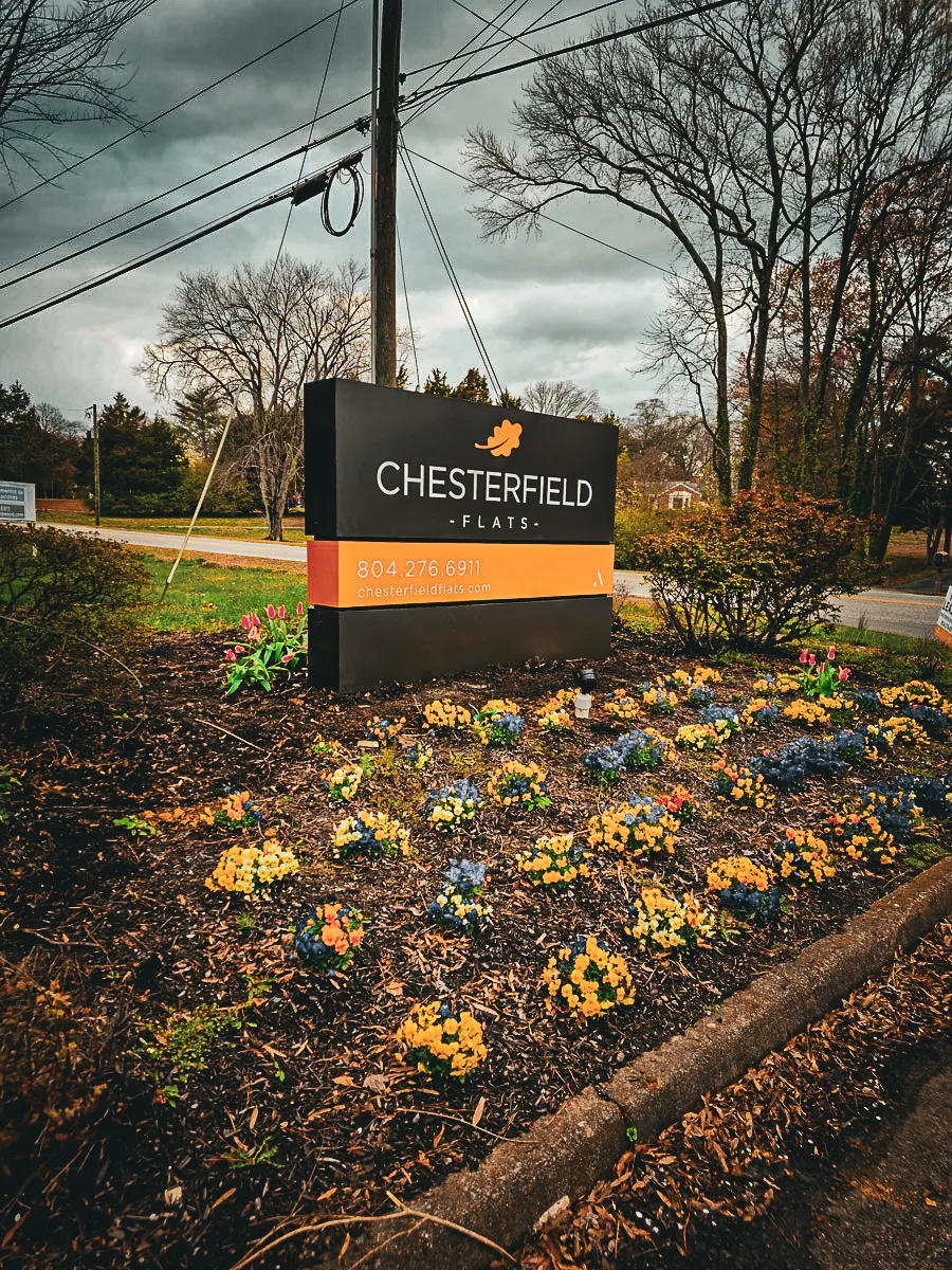 Commercial exterior sign with flowers for Chesterfield Flats apartment complex