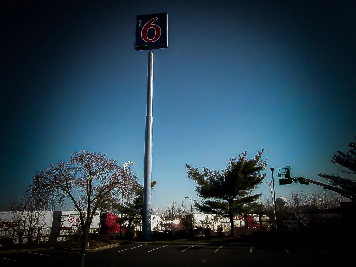 Motel 6 Commercial Exterior Sign with Parking Lot, Trees, and Awnings