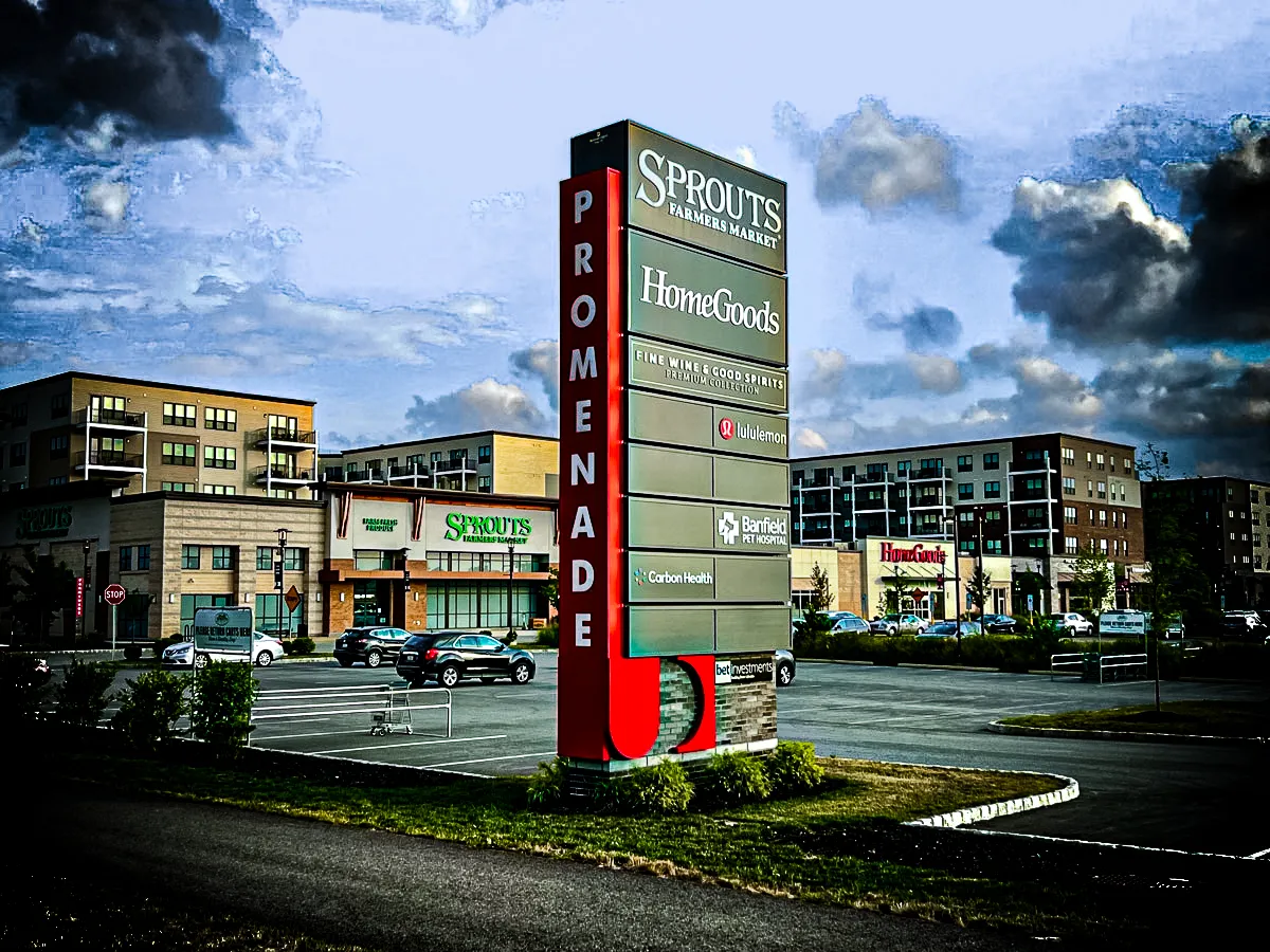 Commercial exterior with Promenade signs, stores, awnings, and shades