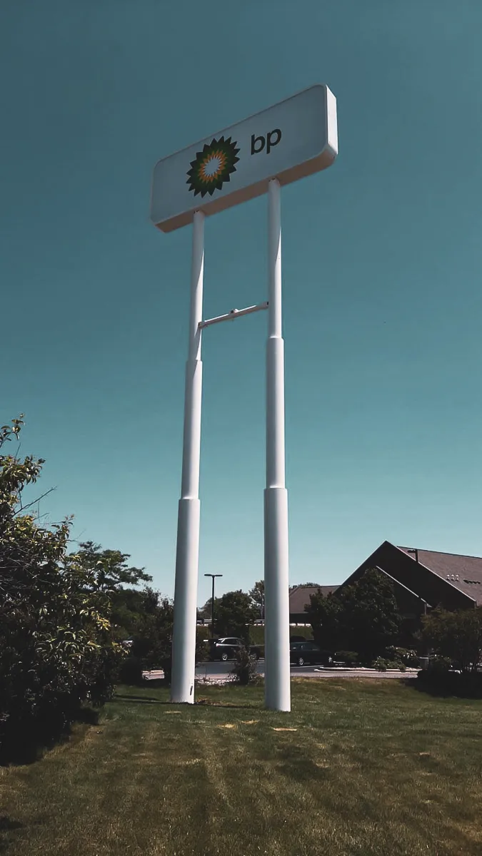 Commercial Exterior BP Sign on Tall White Poles with Awnings and Shades