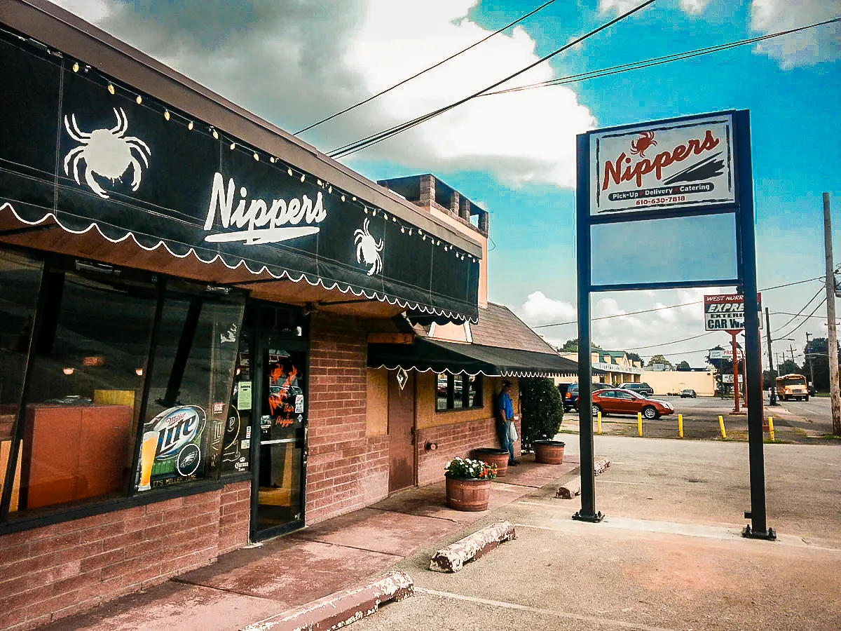 Commercial exterior of Nipper's restaurant with signs, awnings, and shades