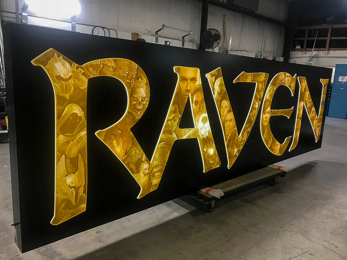 Commercial sign with illuminated yellow Raven logo for exterior or interior display