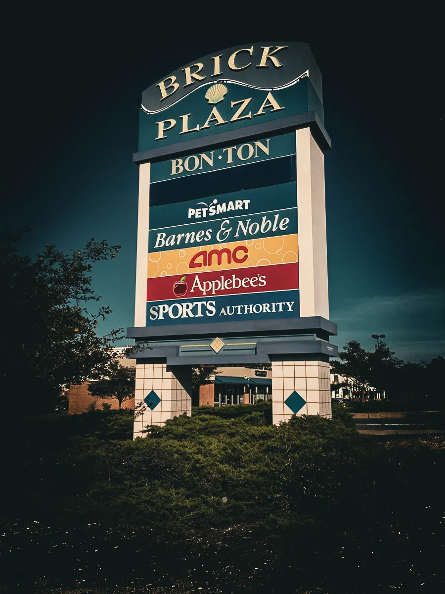 Commercial Brick Plaza exterior sign with multiple store awnings and shades