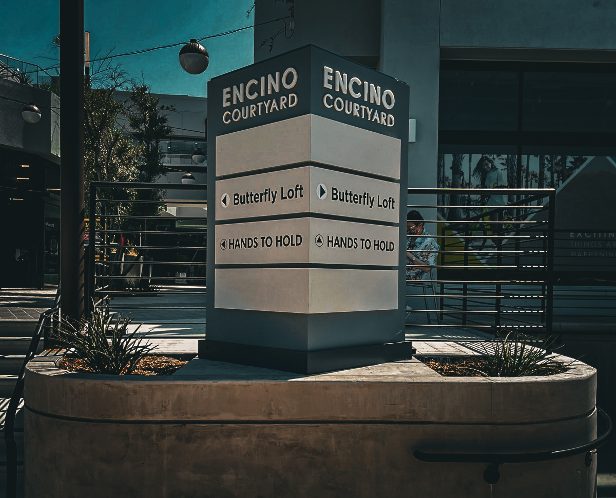 Commercial exterior sign for Encino Courtyard with Butterfly Loft and Hands to Hold