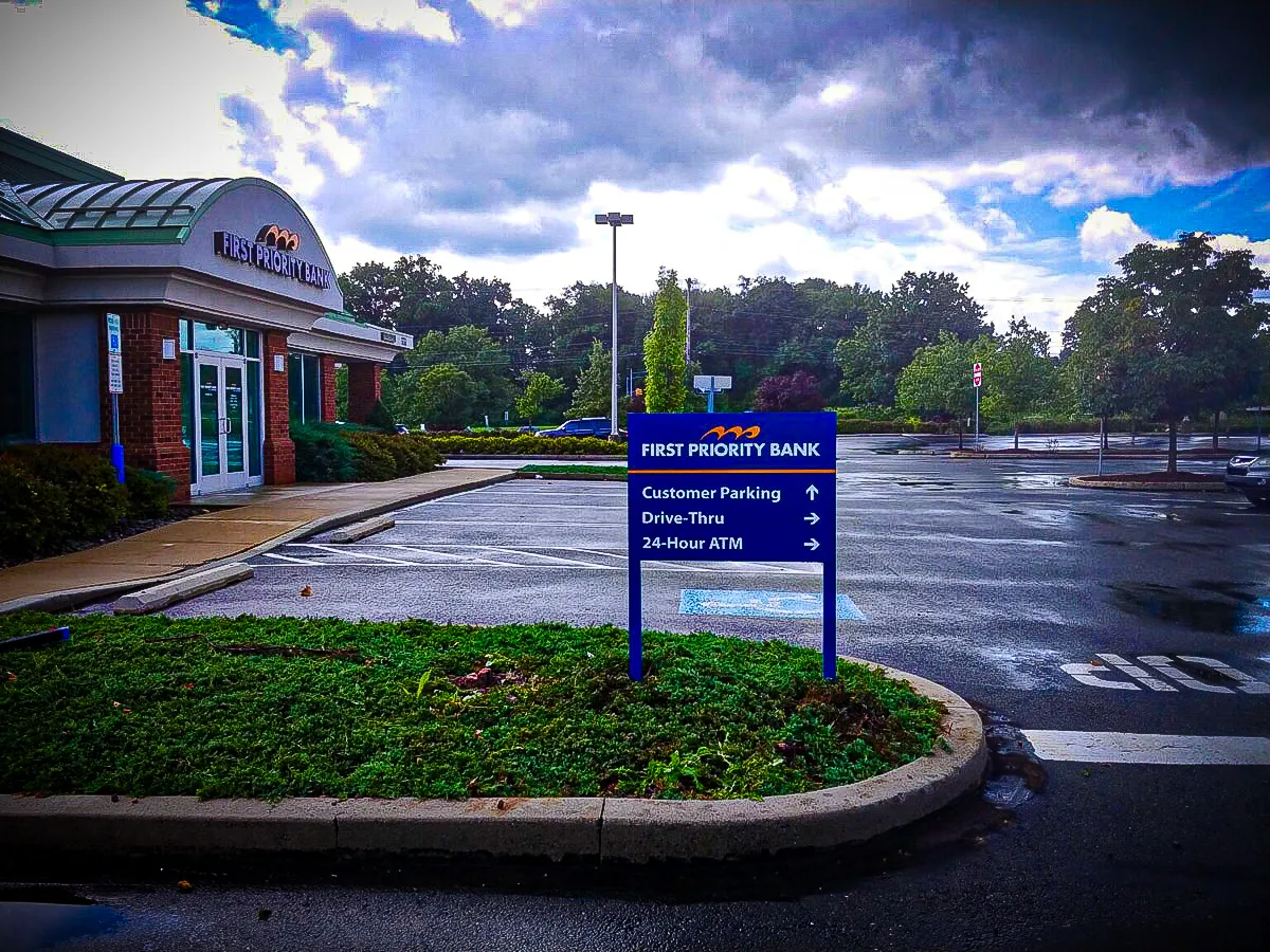 Commercial exterior with First Priority Bank signs, awnings, and parking directions