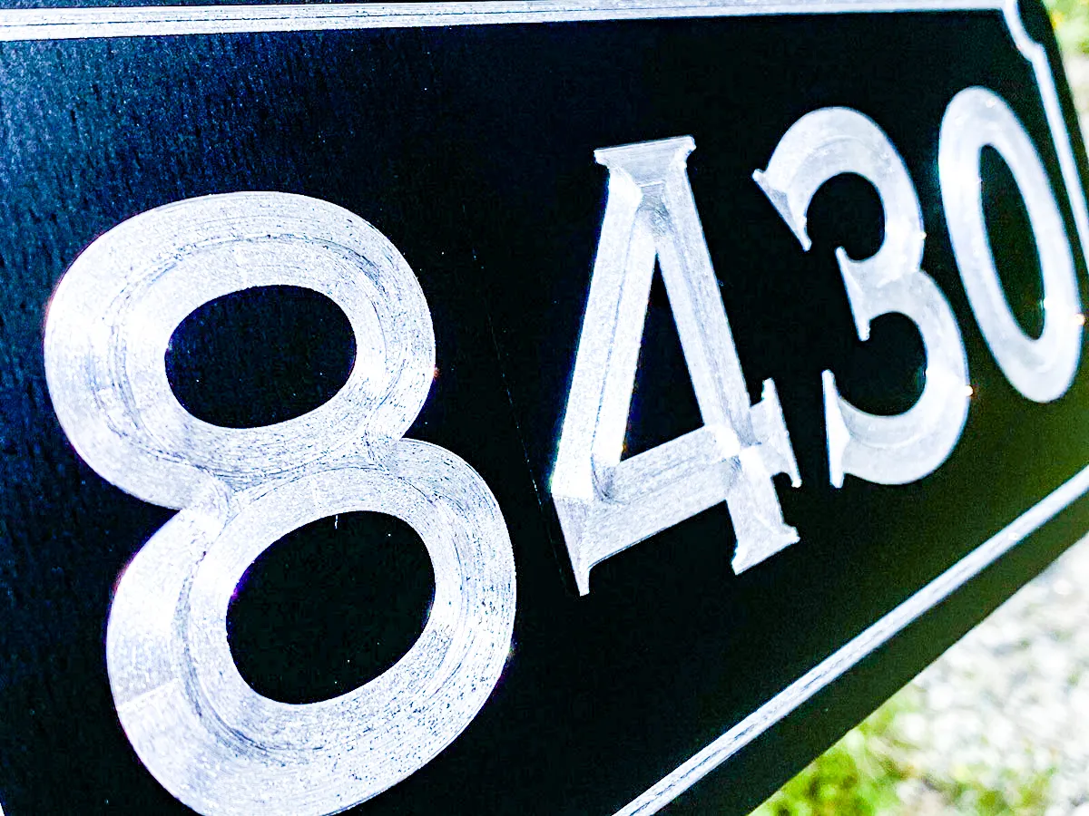 Commercial exterior sign with white numbers 8430 on dark background
