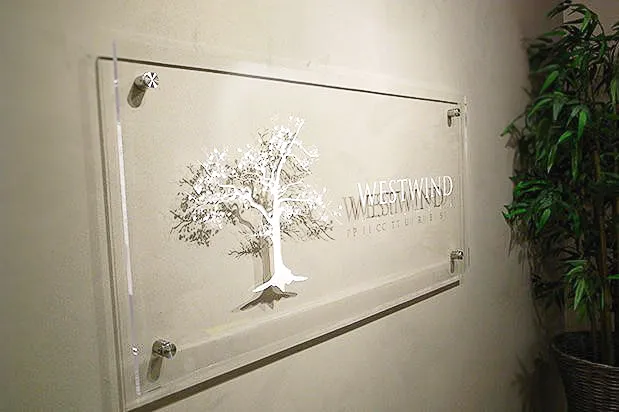 Commercial interior sign with tree logo for Westwind, mounted with exterior shades