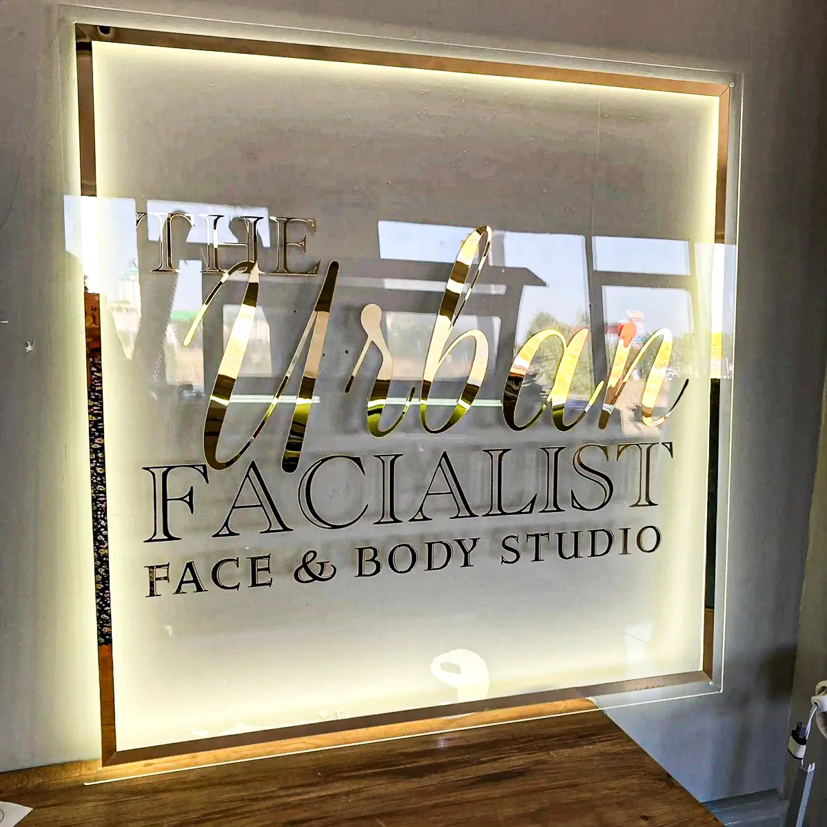 Commercial interior sign for Urban Facialist Face & Body Studio with exterior shades