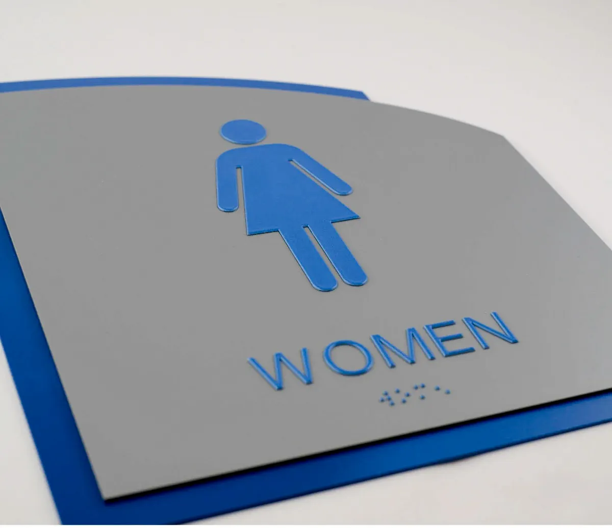 Commercial interior and exterior signs with women's restroom icon and braille
