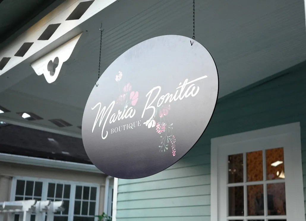 Commercial exterior sign for Maria Bonita Boutique with hanging awning shades