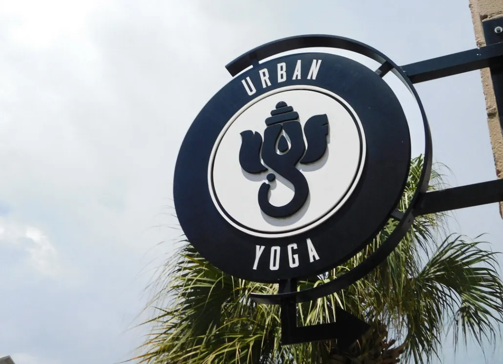 Commercial exterior sign for Urban Yoga with distinctive logo and palm tree
