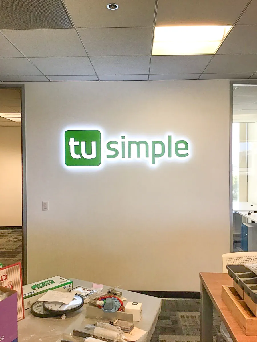 Commercial interior with TuSimple logo sign and workspace details