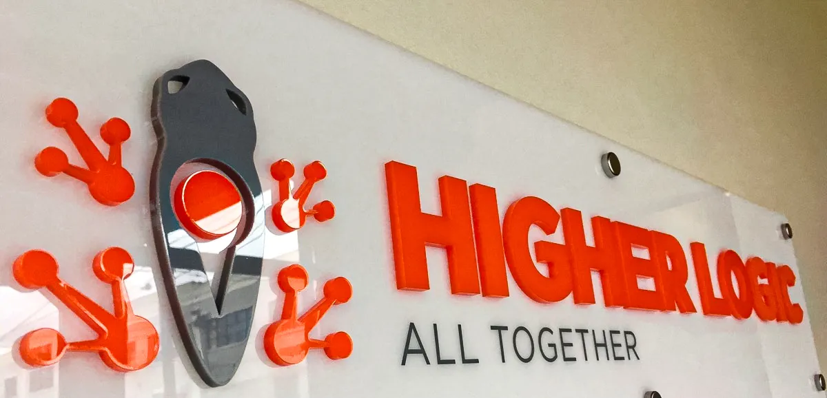 Commercial interior sign for Higher Logic with bold orange and metallic elements