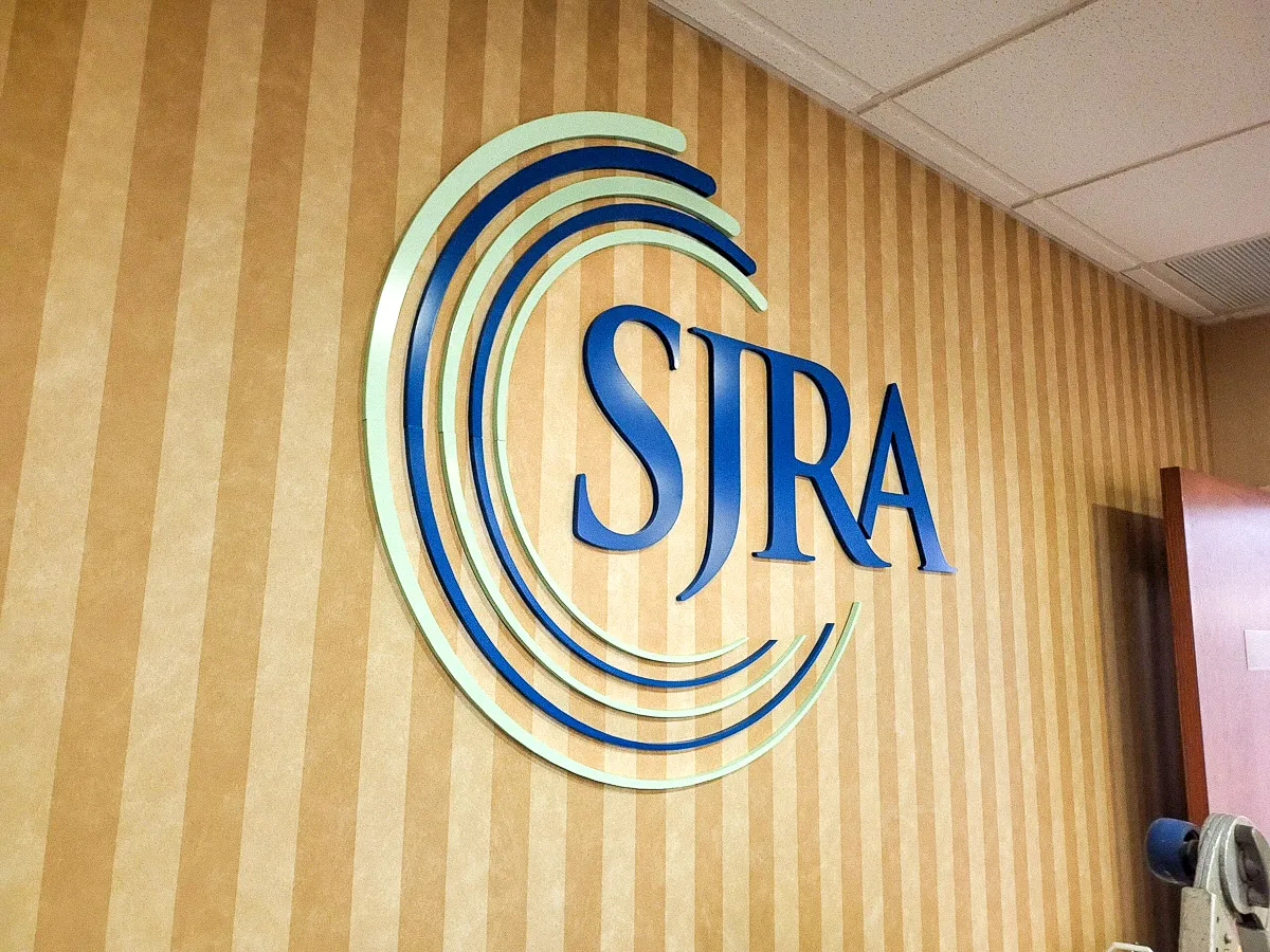 Commercial interior sign with SJRA logo on striped wall with awnings