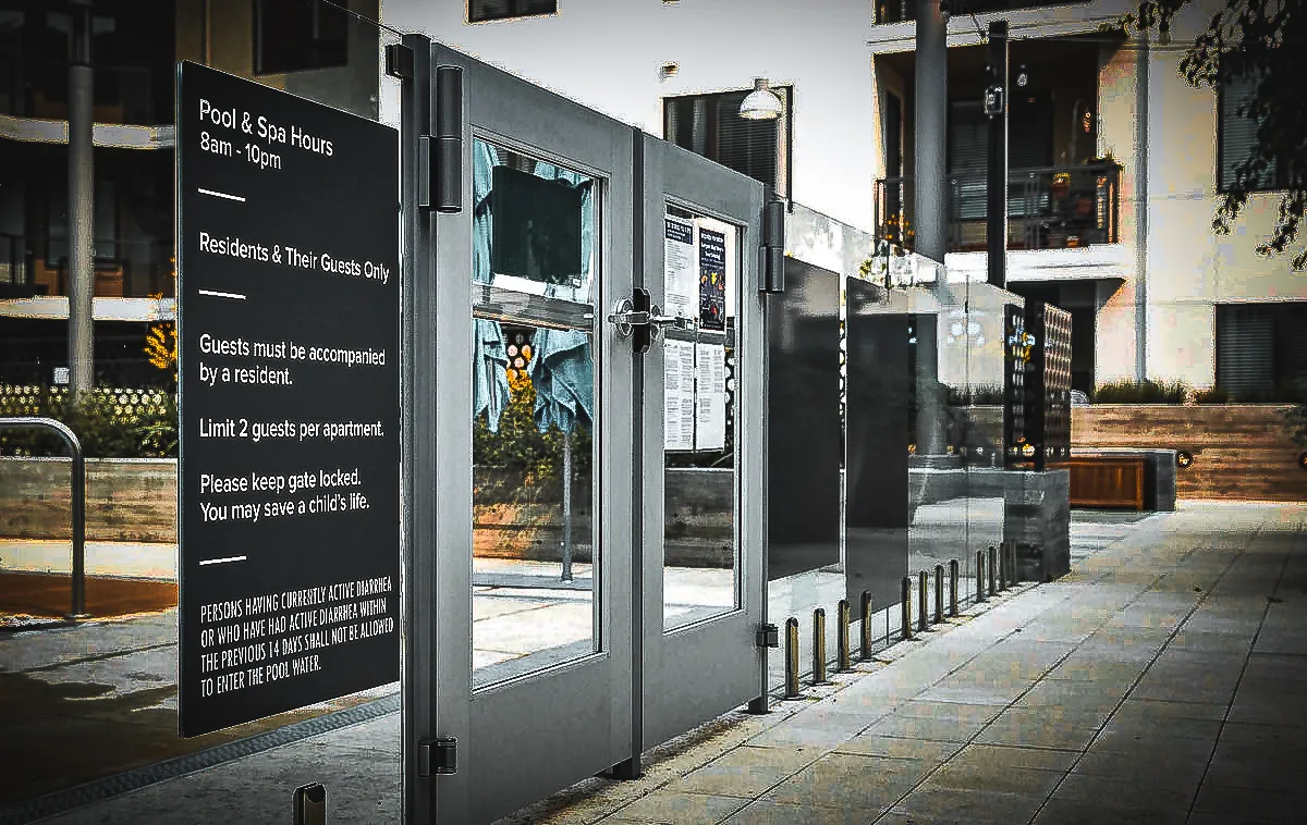 Commercial exterior with pool area signs, glass doors, and restrictive awnings