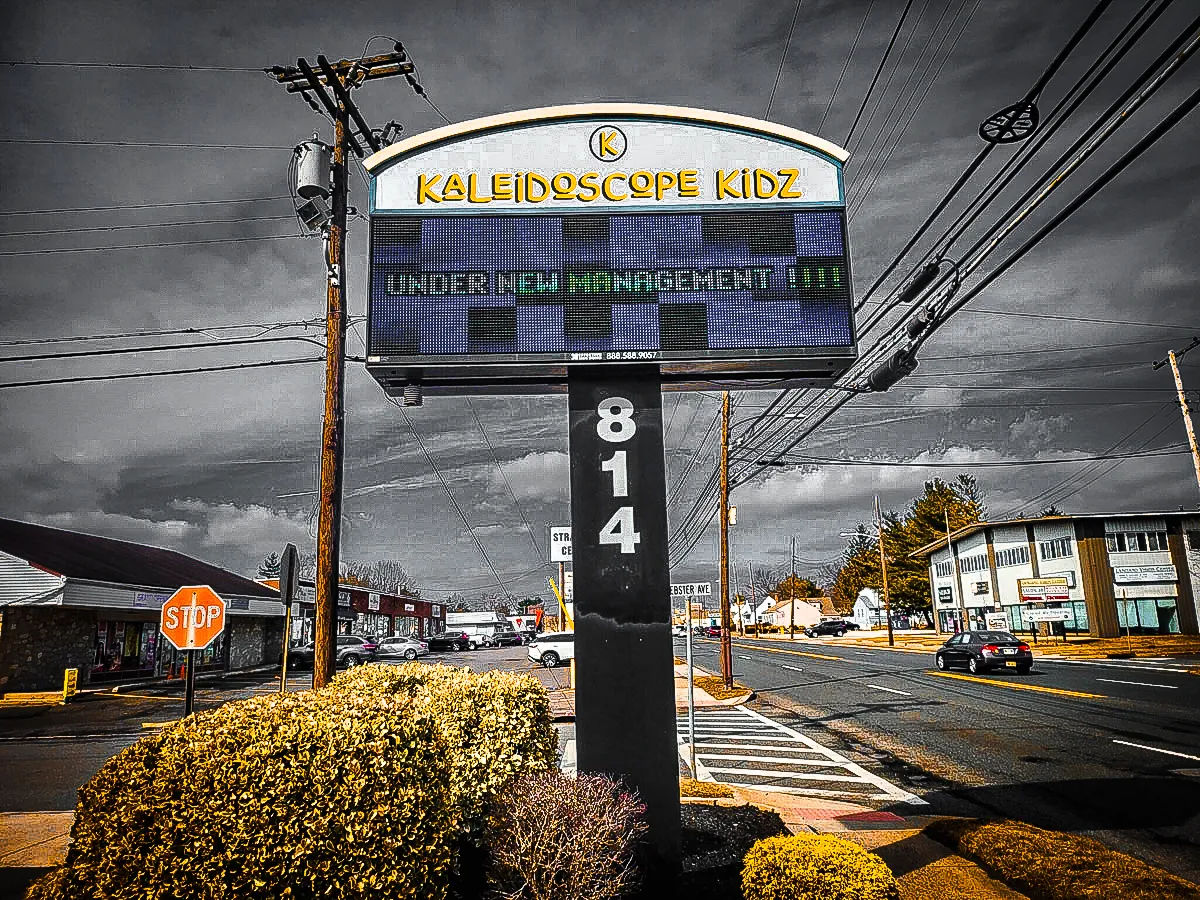 Commercial exterior with Kaleidoscope Kidz sign, awnings, and street intersection