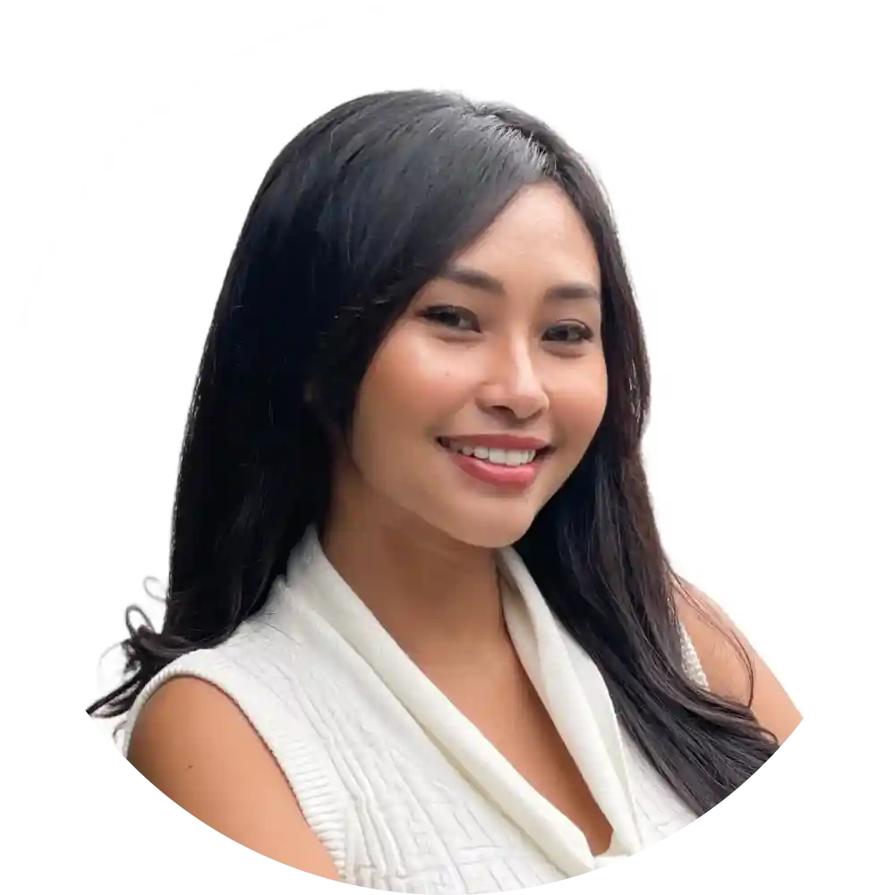 Smiling woman with long dark hair wearing a white sleeveless top.