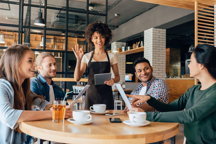 Personnes autour d'une table qui discutent et sourient. Cabinet conseil hôtellerie tourisme