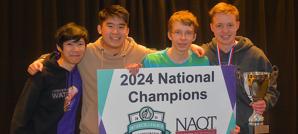 A group of students holding a national champions trophy.