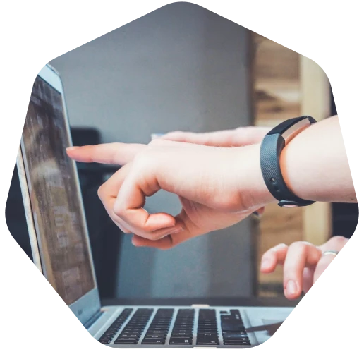 A person pointing at a laptop screen.