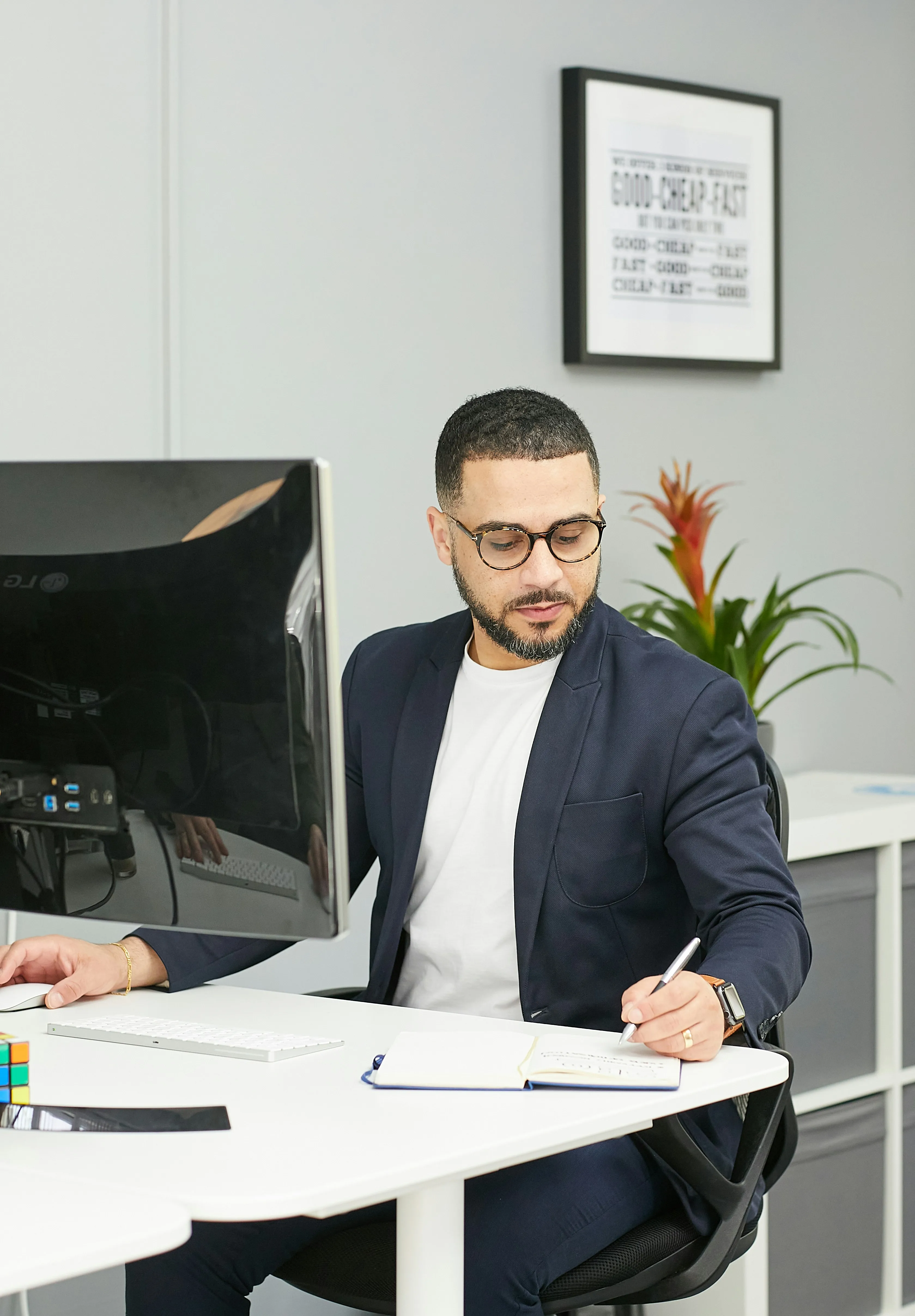 A man sitting at a desk writing on a piece of paper.